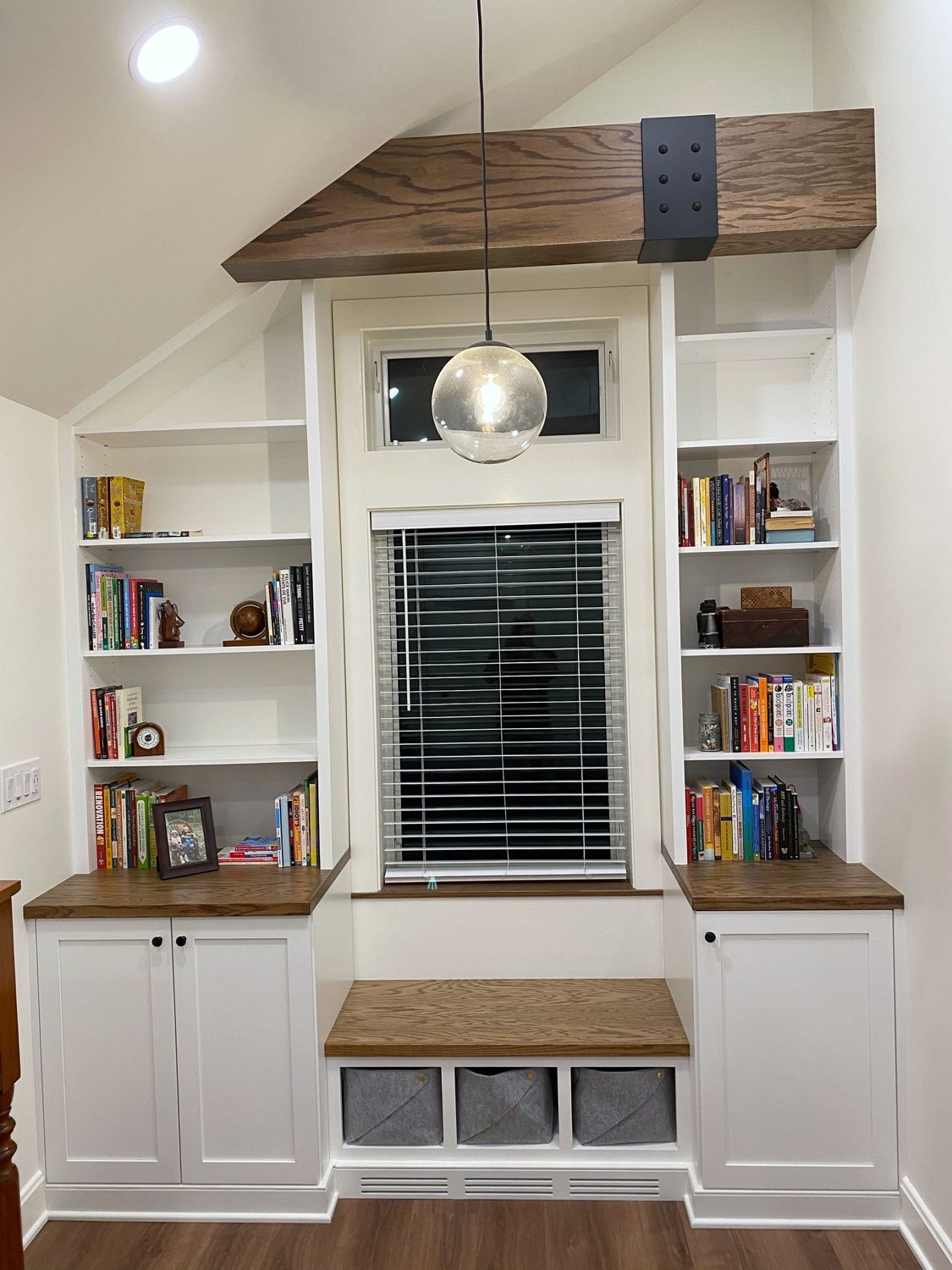 White built-in bookcases around a window seat