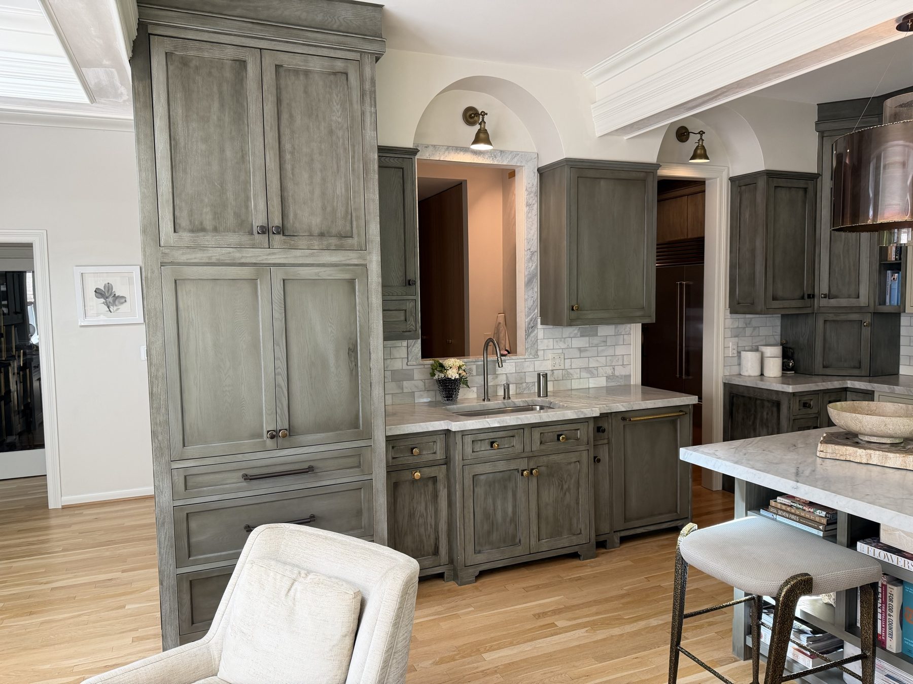 Grey-stained oak cabinetry fitted beneath original plaster arches