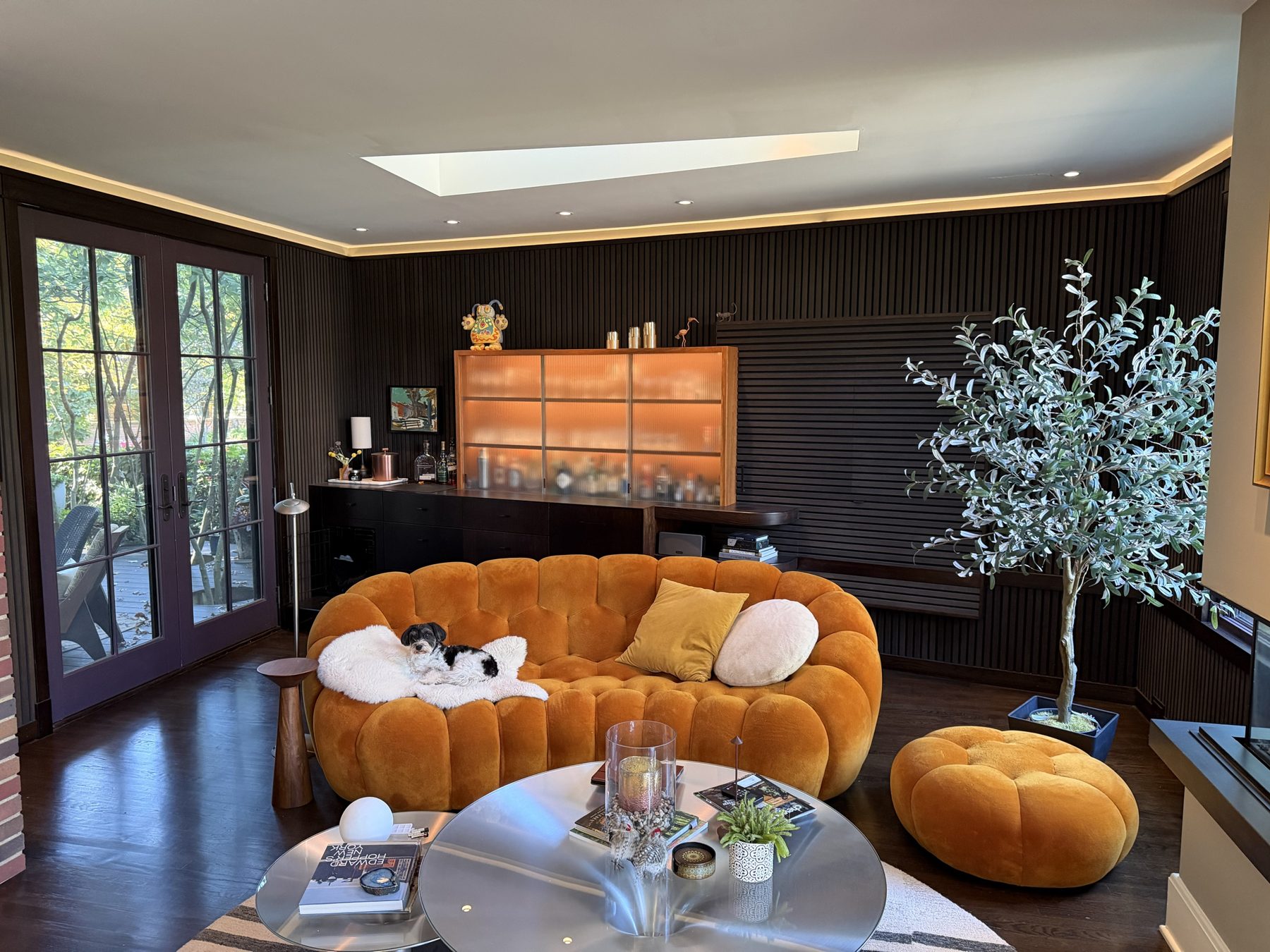 Slat-walled sitting room with a lit reeded-glass bar cabinet and concealed media wall