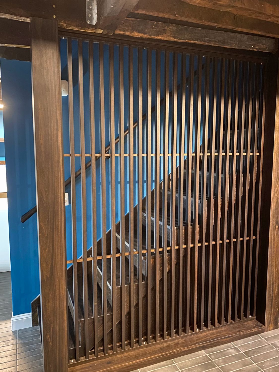 Walnut slat screen beside a staircase