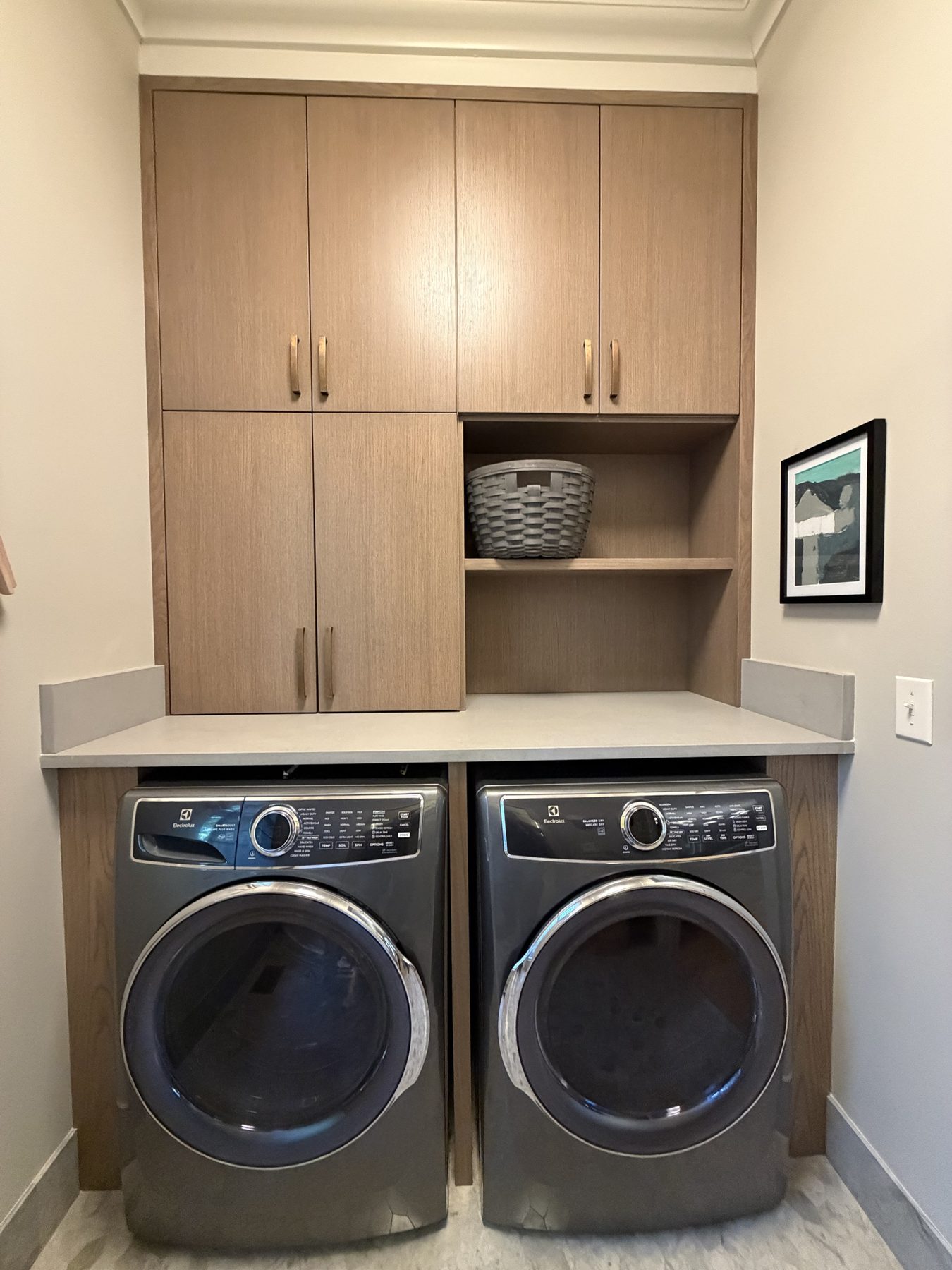 White oak laundry cabinetry built around a washer and dryer
